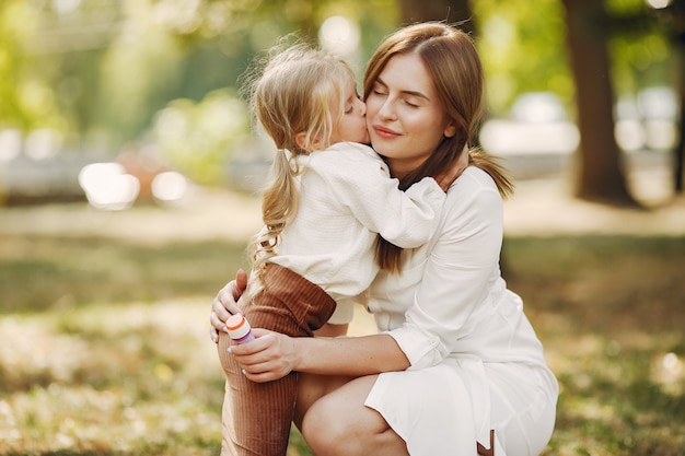 Mother with little daughter playing in a summer park