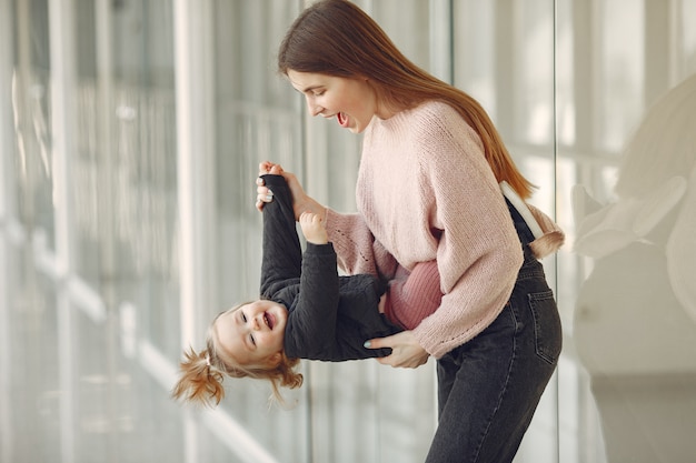 Mother with little daughter standing in a hall