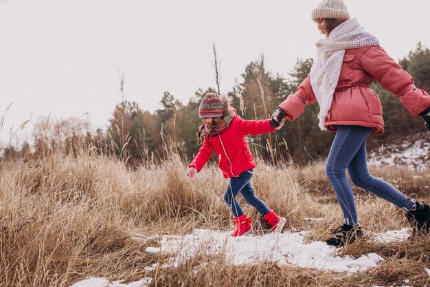 Mother with little daughter in a winter forest