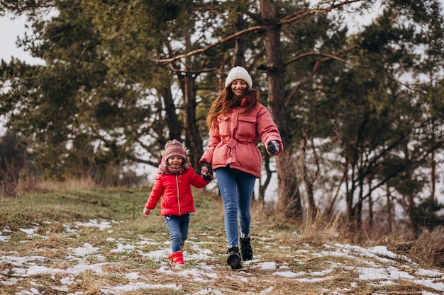 Mother with little daughter in a winter forest