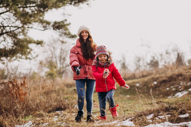 Mother with little daughter in a winter forest