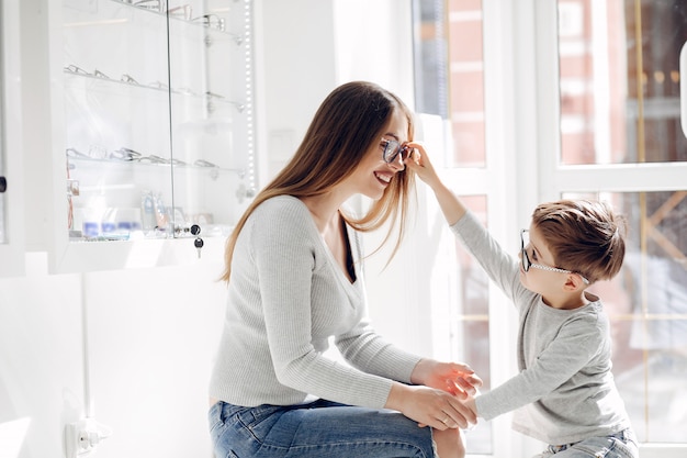 Mother with little son in the glasses store