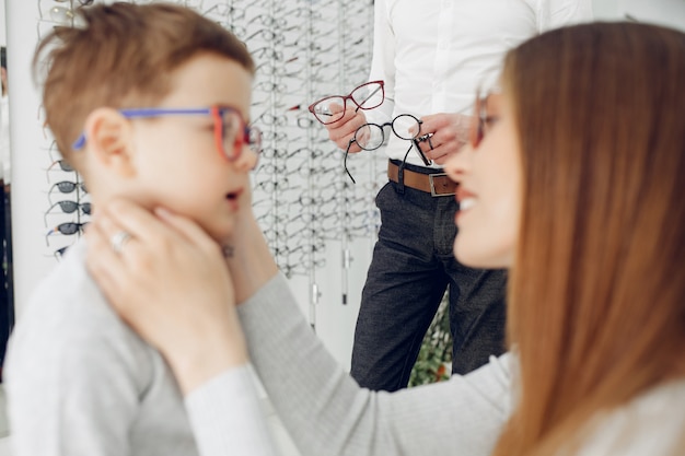 Mother with little son in the glasses store