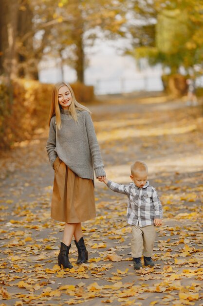 Mother with little son playing in a autumn field