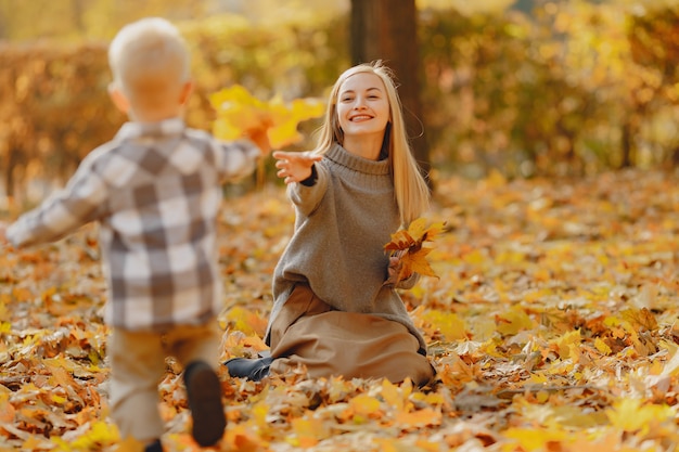 Mother with little son playing in a autumn field