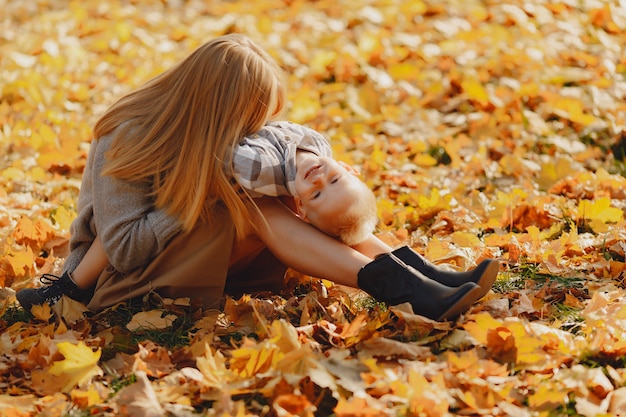 Free photo mother with little son sitting in a autumn field