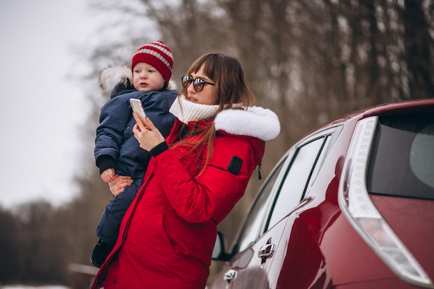 Mother with son standing by car 