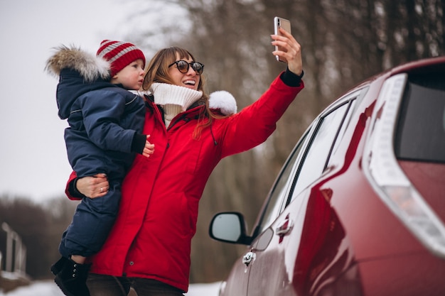 Mother with son standing by car 