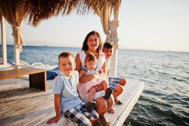 Mother with three kids on Turkey resort sitting bungalow against Mediterranean sea