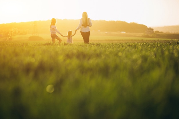 Mother with two daughters in sunset