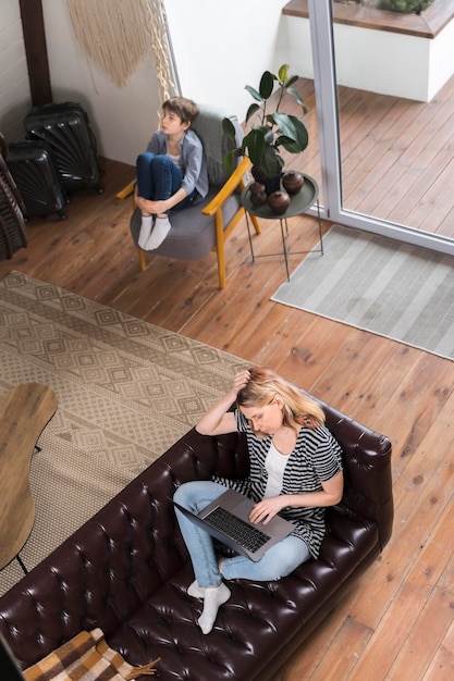 Free photo mother working from home while son is punished