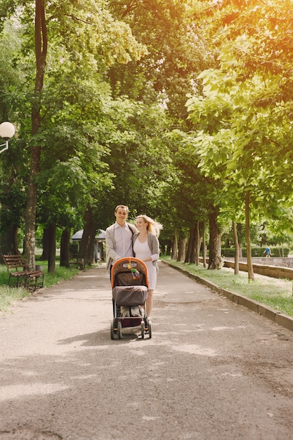 Mother and young father walking their baby in the park