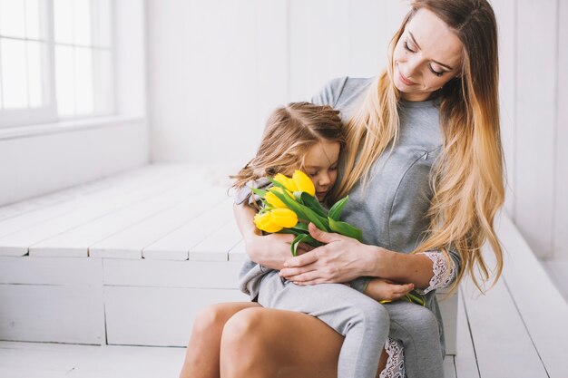 Mothers day concept with sitting mother and daughter