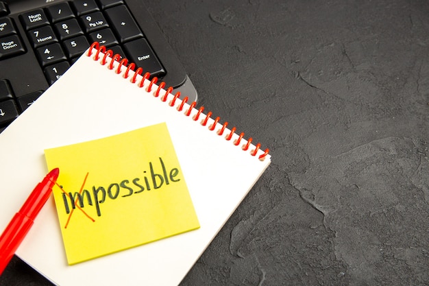 Free photo motivation notes with word impossible over notebook