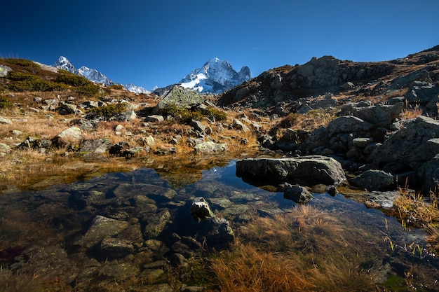 Mount Aiguille Verte from Mont Blanc massif reflecting on the water in Chamonix, France