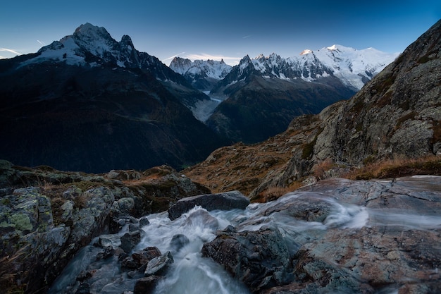 Mount Mont Blanc surrounded by rocks and a river with long exposure in Chamonix, France