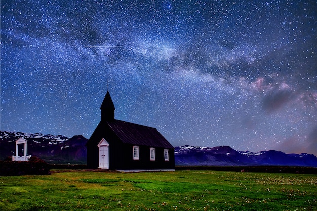 Mountain View Iceland. Fantastic starry sky and the milky way. Beautiful black wooden church in Budir