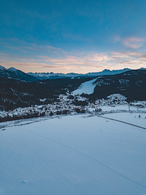 Mountains covered in trees and snow during the sunset in the evening