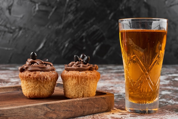 Muffins and cocktail on a wooden board.