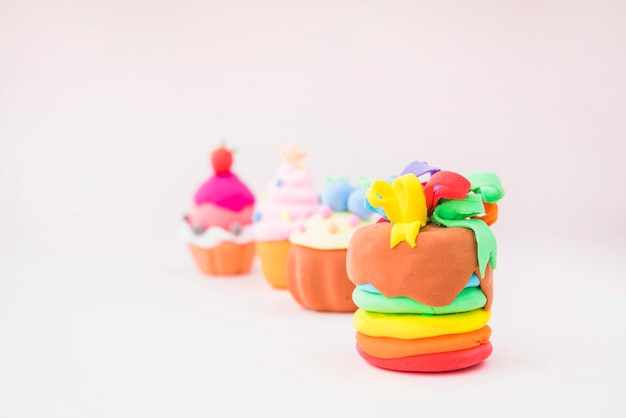 Free photo muffins made with colorful clay on pink background