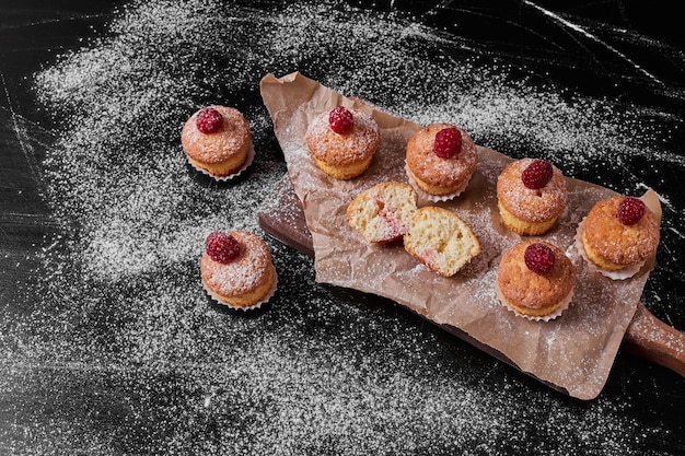 Free photo muffins with berries on wooden platter .