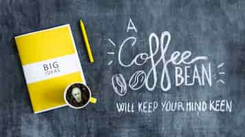 Free photo mug with coffee beans with light bulb over the big ideas book and text on blackboard