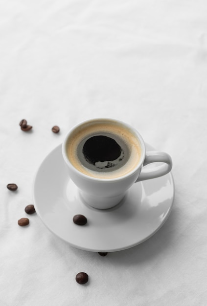 Mug with coffee and coffee beans beside