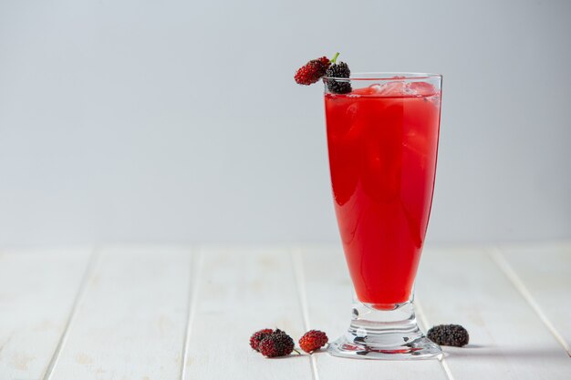 Mulberry juice on white wooden surface