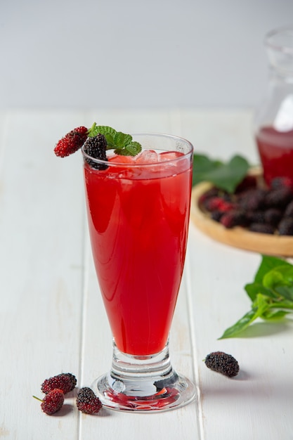 Mulberry juice on white wooden surface