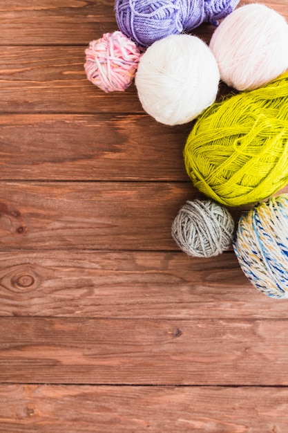 Free photo multi colored ball of yarns on wooden background