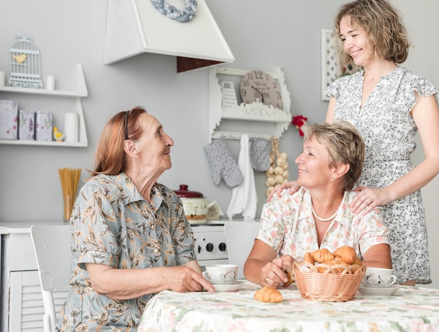 Free photo multi generation women having breakfast in kitchen