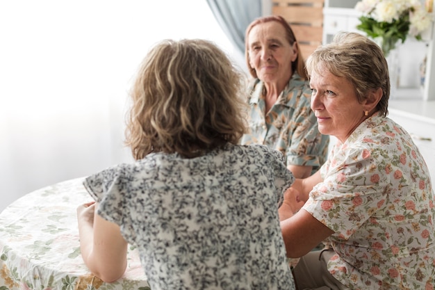 Multi generation women sitting in kitchen having breakfast