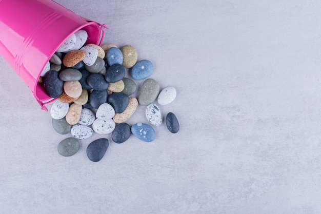 Free photo multicolor beach stones in a platter on concrete surface