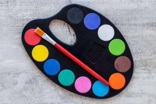 Free photo multicolored artist tray palette on wooden background