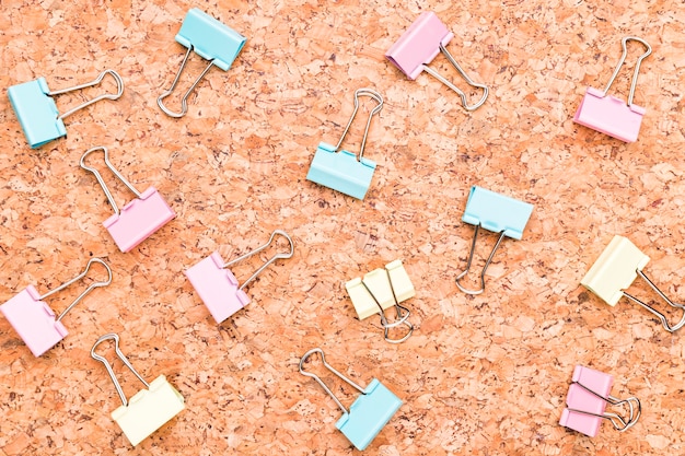 Multicolored binder clips on wooden desk