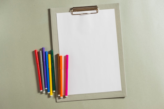 Multicolored felt-tip pens and clipboard with blank paper