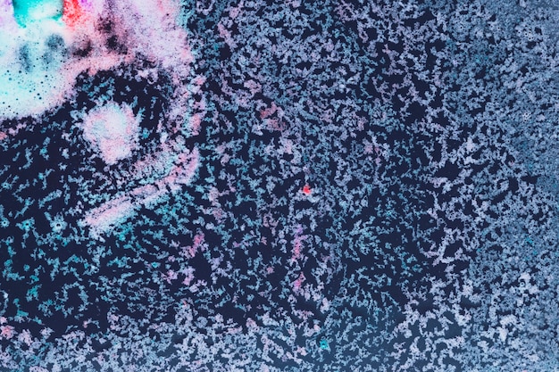 Multicolored foam on dark blue water