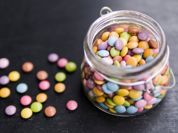 Free photo multicolored glazed candies in glass jar