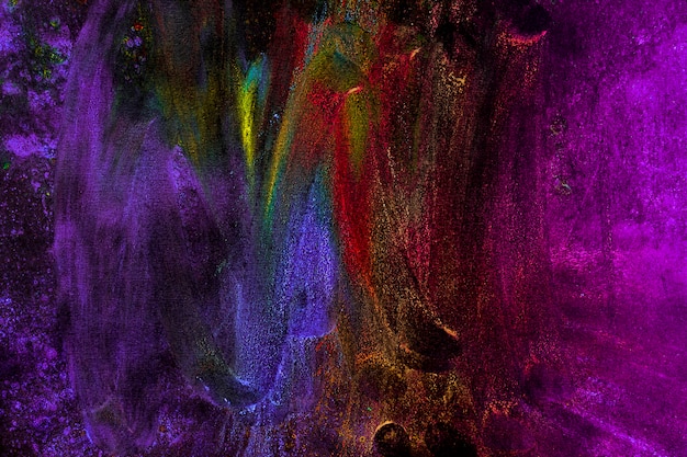 Multicolored holi colors smudged with hand on black background