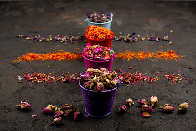 Multicolored leafs flower and other colorful particles in pots on a grey desk