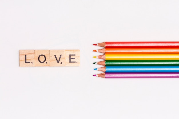 Free photo multicolored pencils and love lettering