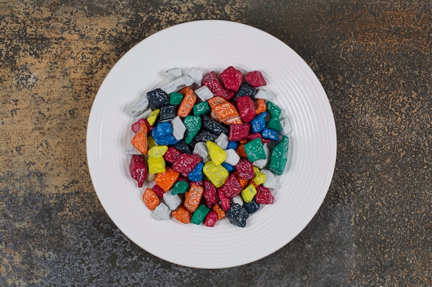 Free photo multicolored stone candies on white plate.