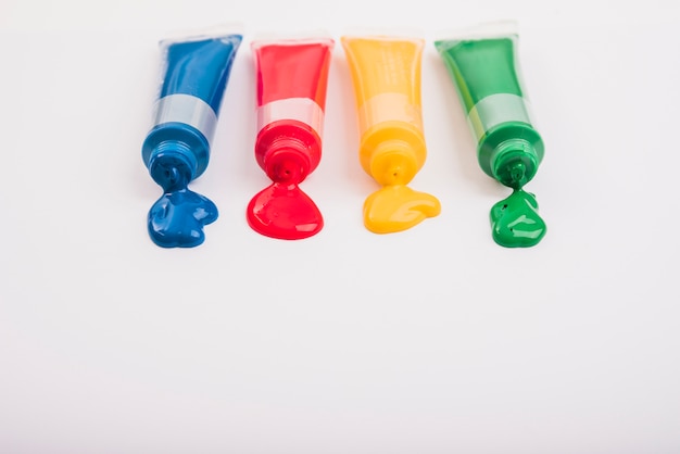 Free Photo multicolored tubes with squeezed watercolors on white background