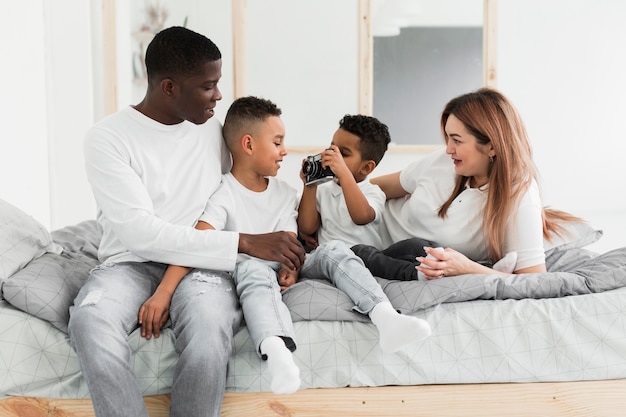 Multicultural family playing with a camera indoors