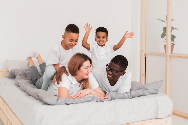 Free photo multicultural family staying in bed together