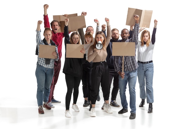 Multicultural group of people screaming while holding blank placards on white wall