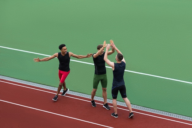 Free photo multiethnic athlete team standing on running track