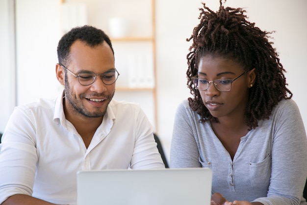 Free photo multiethnic colleagues using laptop