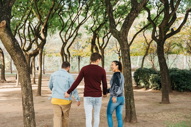 Free photo multiethnic friends laughing and walking in park