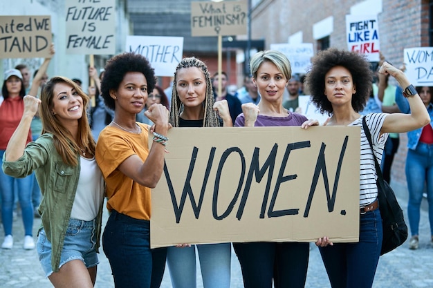 Free photo multiethnic group of females flexing their biceps while participating in a protests for women's rights